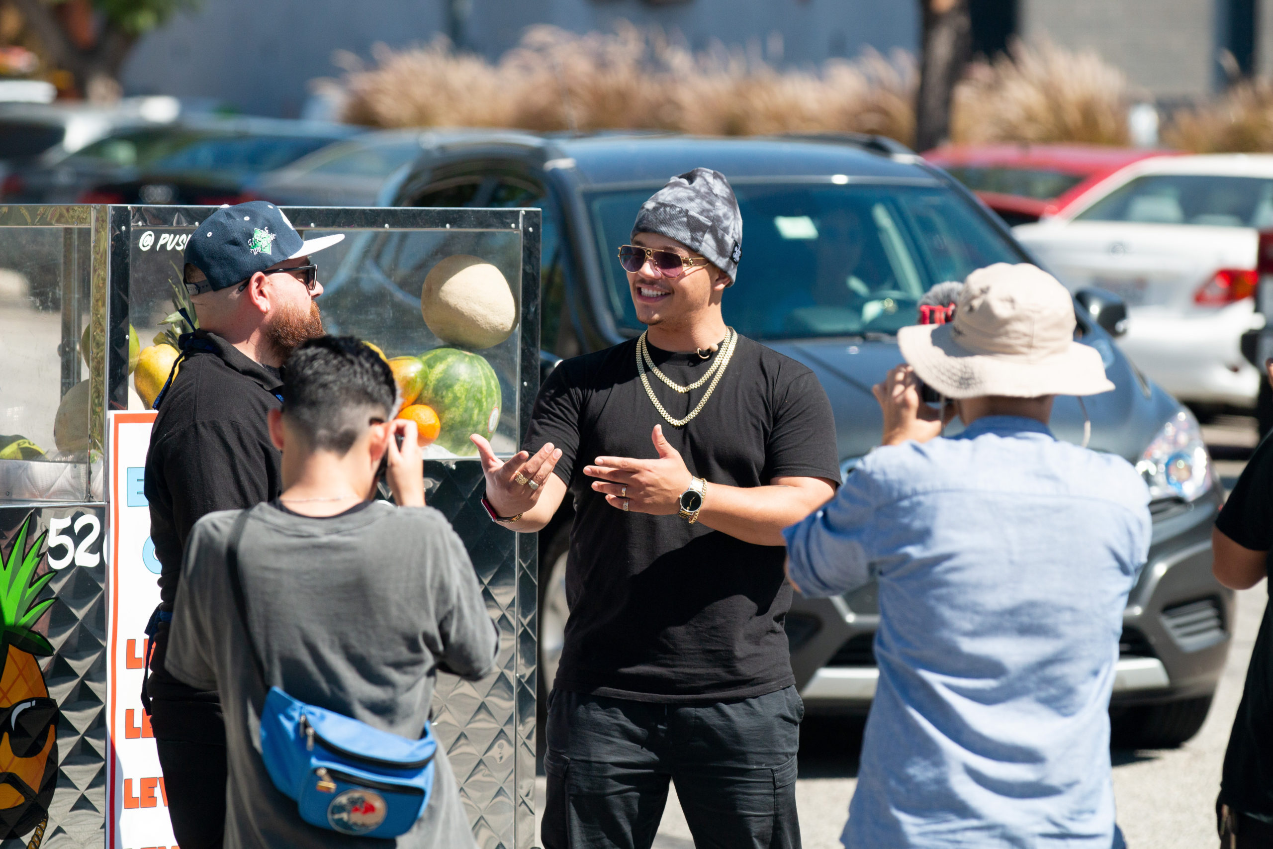 Leading video creator SpicyyCam standing in front of cameras while recording content in an outdoors area with cars in the background